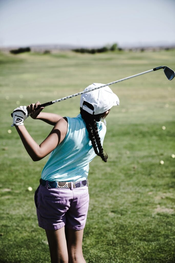 Professional female golf player in mid-swing on a tournament course